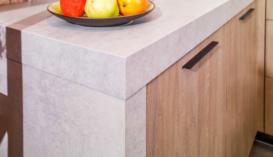 Het kunststof werkblad heeft een betonlook kleur, wat goed past bij de industriële stijl van de keuken