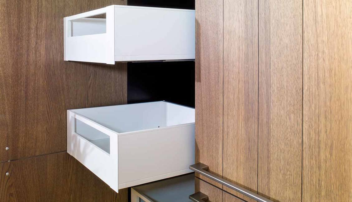 De houten kastenwand biedt veel opbergruimte, zeker dankzij de ingebouwde lades