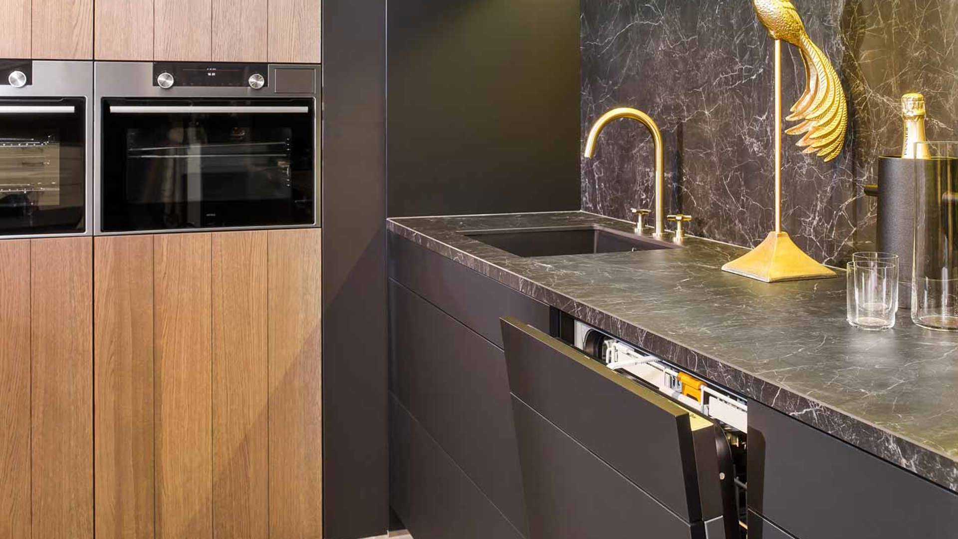 De combinatie van zwarte en houtkleur tinten geven deze keuken een chique uitstraling