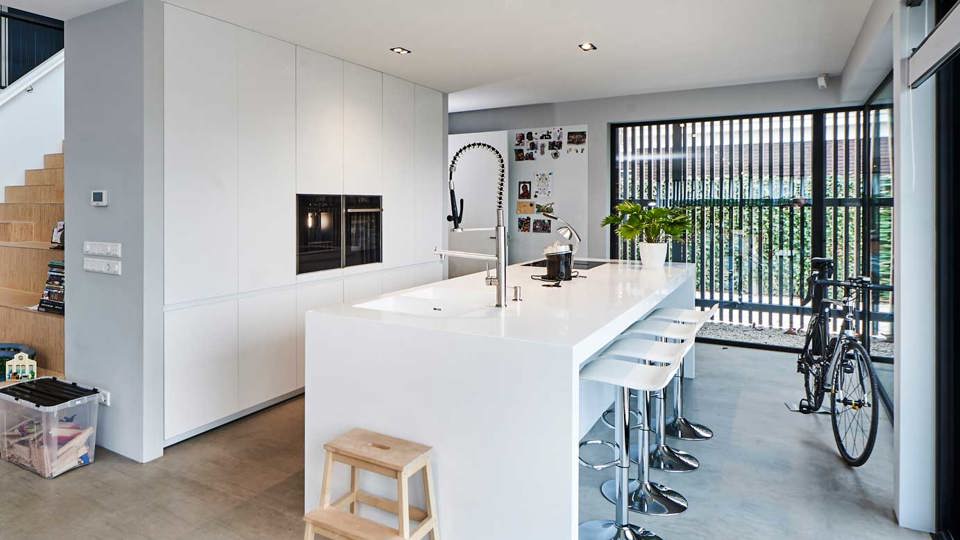 Witte chique keuken met eiland, bar en kastenwand