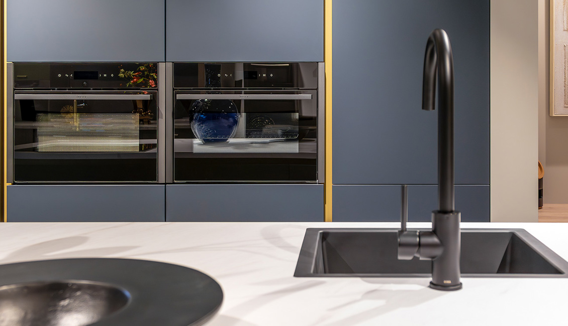 Blauwe rechte keuken met marmerwerkblad en gouden accenten