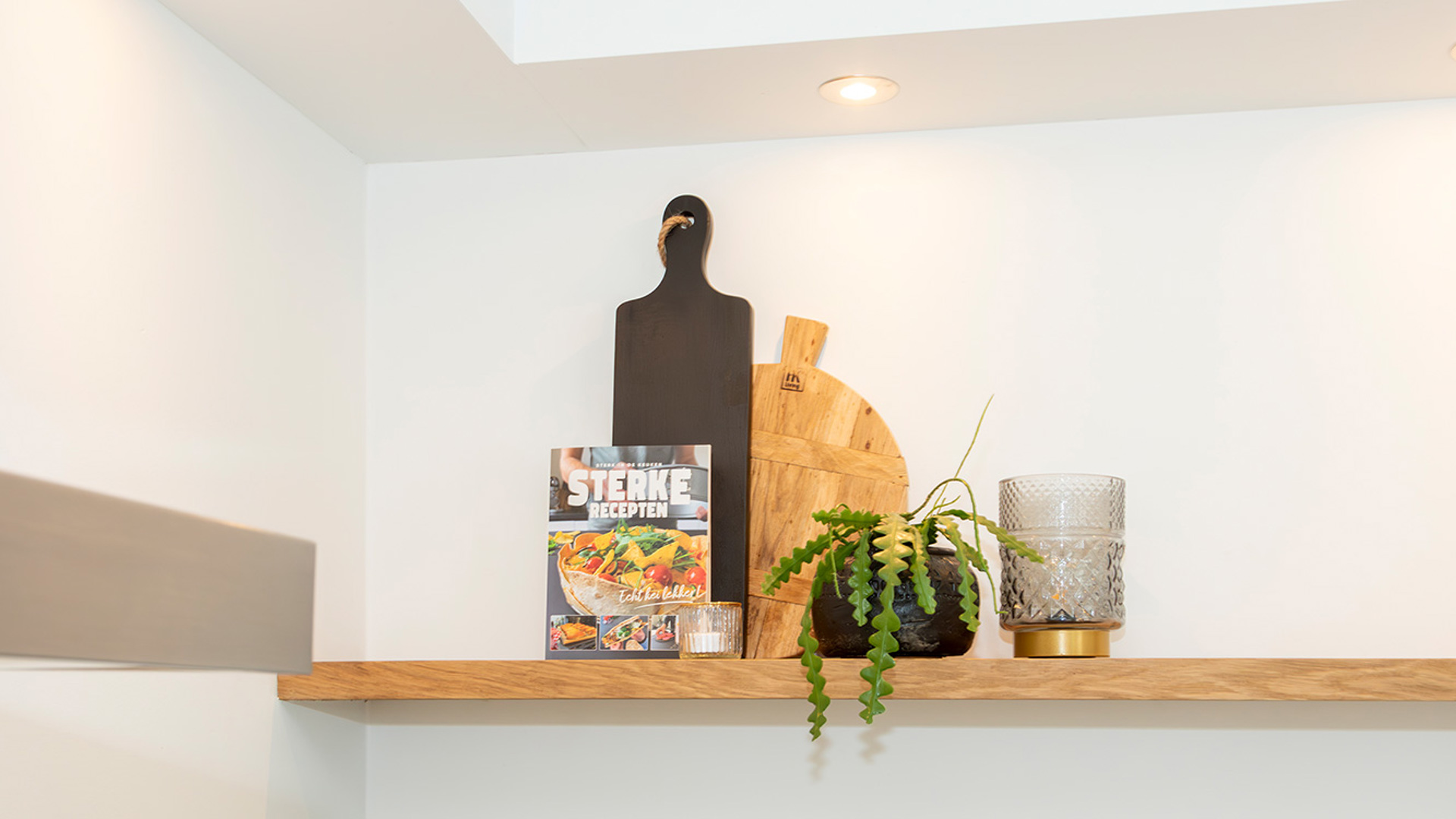 Houten plank boven witte greeploze moderne keuken